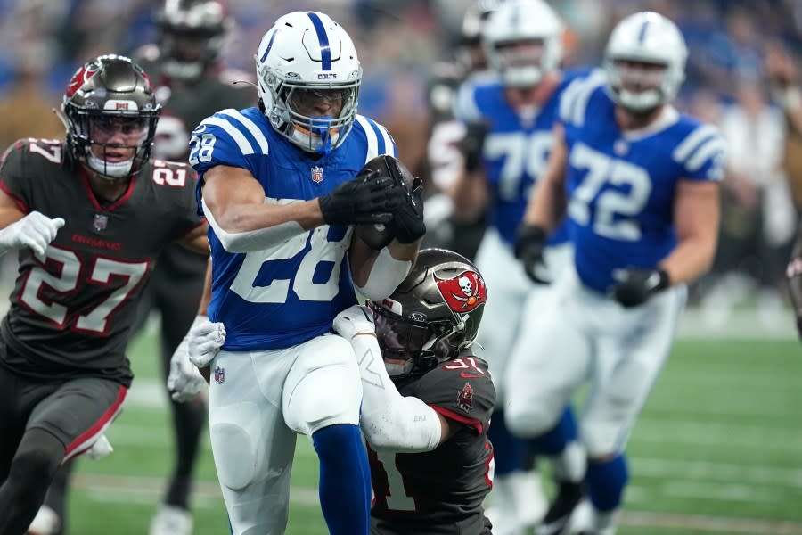 Indianapolis Colts running back Jonathan Taylor (28) runs the ball as Tampa Bay Buccaneers safety Antoine Winfield Jr. (31) tackles him during the first half of an NFL football game Sunday, Nov. 26, 2023, in Indianapolis. (AP Photo/Darron Cummings)