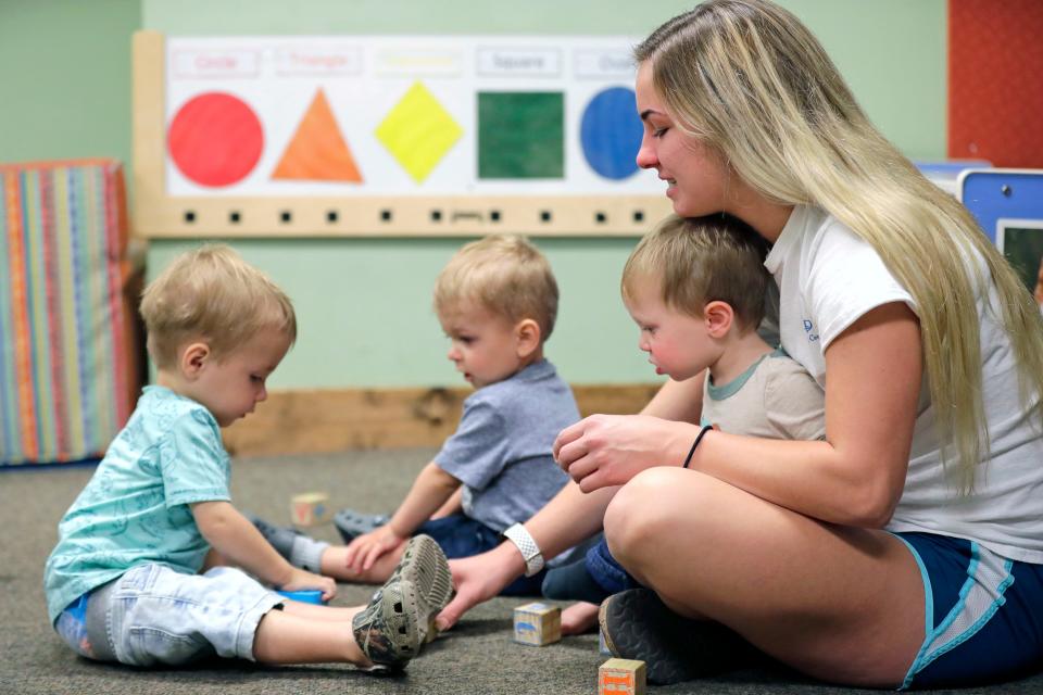 Assistant teacher Taylor Schulz plays with Aydin Schumacher, left, Landon Thiel, and Boone Heller, right, in the Sunshine classroom for 1-year-olds at Inspire Dreams Group Child Care on Aug. 31, 2022. The business is located in Calumet County and received ARPA funding.