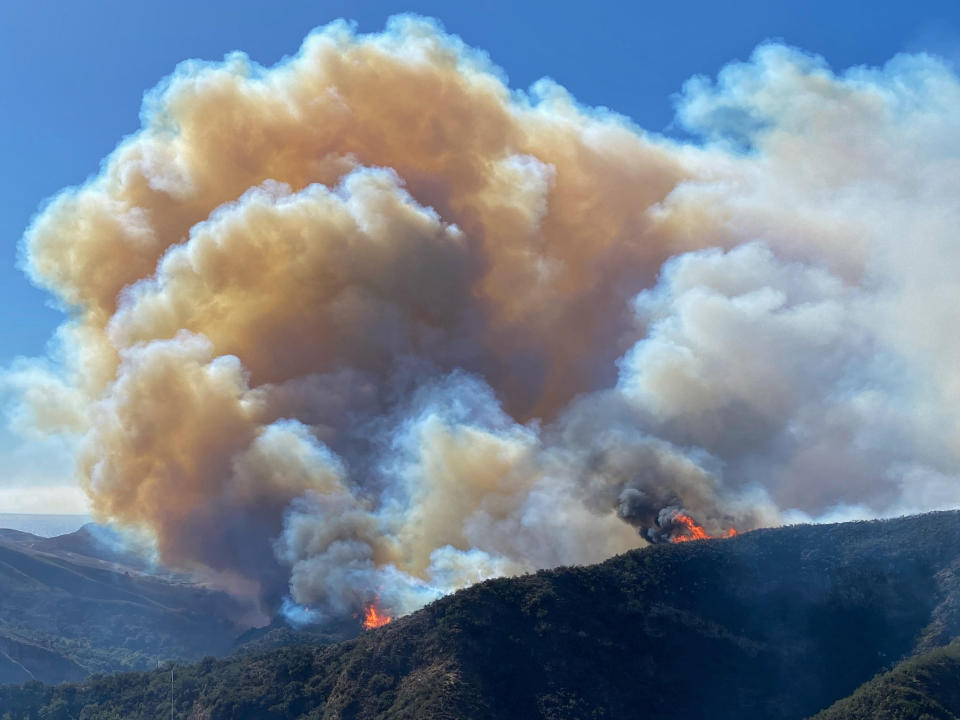 In this photo provided by Santa Barbara County Fire Department, the Alisal Fire continues to burn the dry vegetation in Refugio Canyon on Tuesday morning, Oct. 12, 2021, in Santa Barbara County, Calif. (Mike Eliason/Santa Barbara County Fire via AP)