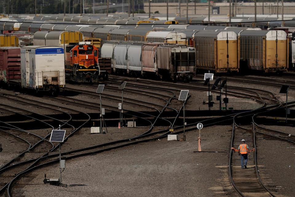 FILE - A worker walks along tracks at a BNSF rail yard Sept. 14, 2022, in Kansas City. The third largest railroad union rejected its deal with freight railroads Monday, Oct. 10, 2022, renewing the possibility of a strike that could cripple the economy. (AP Photo/Charlie Riedel, File)