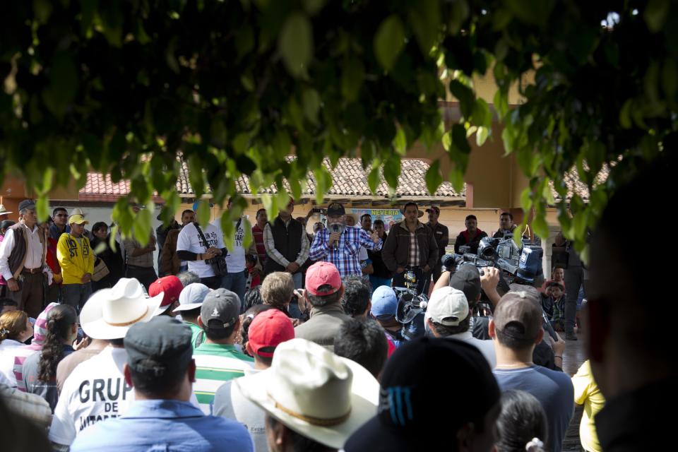 Self-defense group spokesman Estanislao Beltran speaks to the people of Tancitaro, Michoacan, Mexico, Thursday, Jan. 16, 2014. Mexico's spreading vigilante movement announced its first big land hand-out, returning 25 avocado orchards to farmers whose properties had been seized by the cartel, which started in drug trafficking and expanded to extortion and economic control. Such moves are expanding the strength and popularity of the vigilantes even as the government demands they disarm. (AP Photo/Eduardo Verdugo)