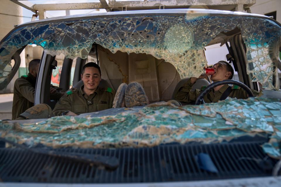Israeli soldiers rest in a damaged car, during an urban warfare exercise at an army training facility at the Zeelim army base, southern Israel, Jan. 4, 2022.