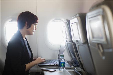 A woman uses her computer to test a new high speed in-flight Internet service named Fli-Fi while on a special JetBlue media flight out of John F. Kennedy International Airport in New York, in this file picture taken December 11, 2013. REUTERS/Lucas Jackson/Files