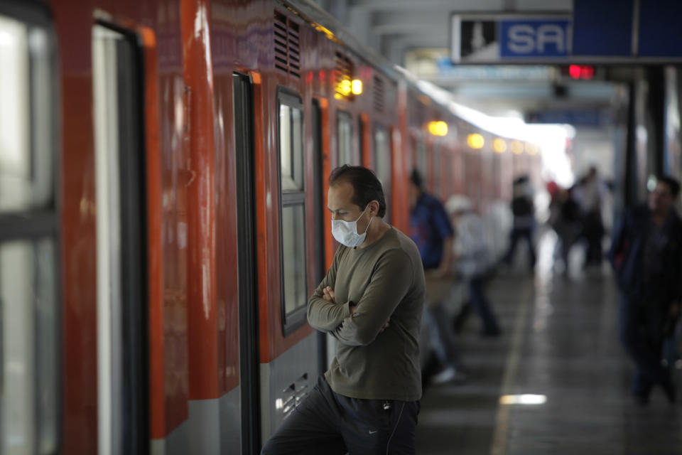 A commuter wears a protective mask to prevent infection from swine flu at a subway station in Mexico City, Friday, May 1, 2009. (AP Photo/Eduardo Verdugo)