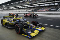 Colton Herta, foreground, Scott McLaughlin, back right, and Pato O'Ward drive in the pit area during a caution period in the IndyCar Grand Prix auto race at Indianapolis Motor Speedway, Saturday, May 14, 2022, in Indianapolis. (AP Photo/Darron Cummings)