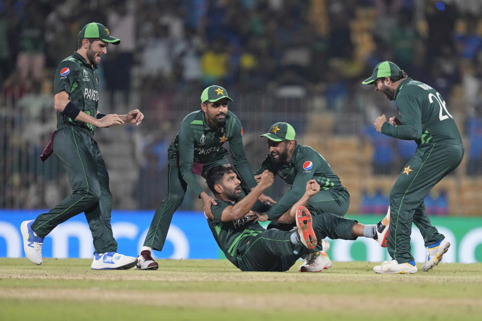Pakistan's Haris Rauf is on the ground after taking the catch to get South Africa's Lungi Ngidi out as teammates rush to congratulate him during the ICC Men's Cricket World Cup match between Pakistan and South Africa in Chennai, India, Friday, Oct. 27, 2023. (AP Photo/Ajit Solanki)