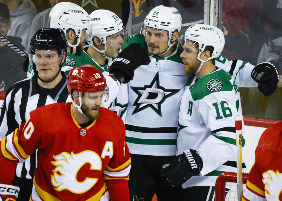 Dallas Stars forward Joe Pavelski, right, celebrates his goal with teammates as Calgary Flames forward Jonathan Huberdeau, left, skates away during the first period of an NHL hockey game Saturday, March 18. 2023, in Calgary, Alberta. (Jeff McIntosh/The Canadian Press via AP)