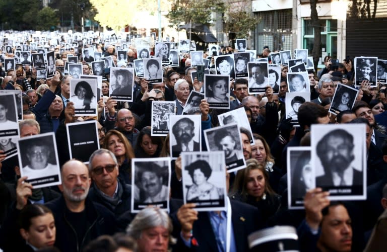 Centenares de personas marcharon con fotografías de las víctimas durante un acto para conmemorar el 30 aniversario del ataque con bomba a la Asociación Mutual Israelita de Argentina (AMIA) en Buenos Aires, el 18 de julio de 2024 (TOMAS CUESTA)