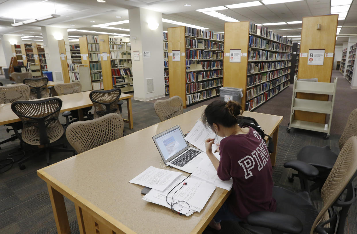 In this June 20, 2019, photo a student works in the library at Virginia Commonwealth University in Richmond, Va. Those who graduate college with student loans owe close to $30,000 on average, according to the most recent data from the Institute for College Access & Success. (AP Photo/Steve Helber)