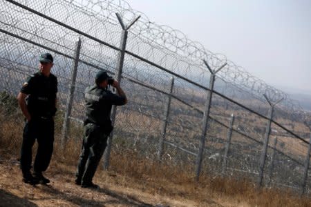 Bulgarian border policemen stand near the barbed wire fence constructed on the Bulgarian-Turkish border, near Lesovo, Bulgaria September 14, 2016. REUTERS/Stoyan Nenov