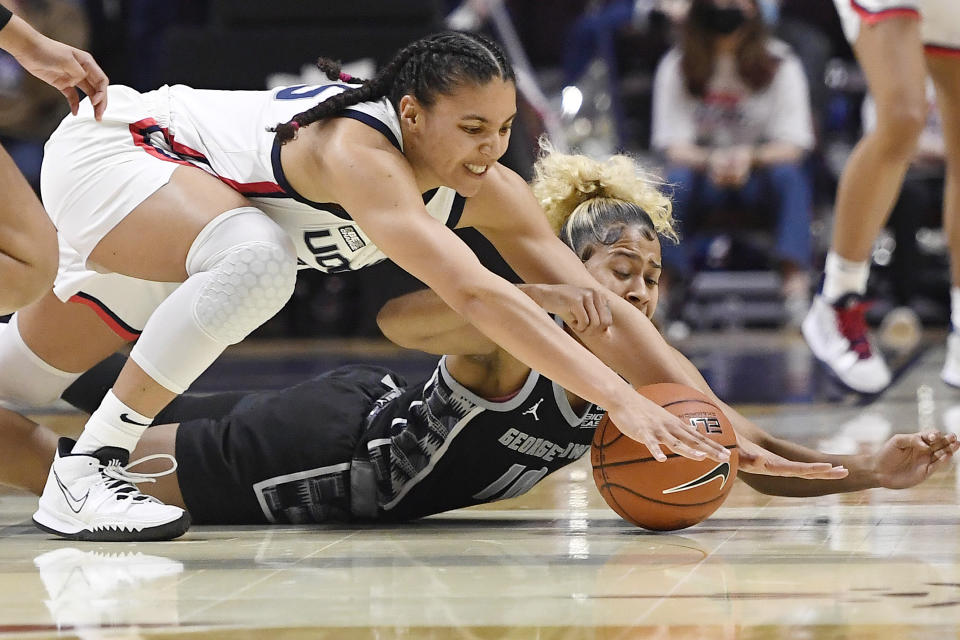 Connecticut's Azzi Fudd, top and Georgetown's Kaylin West, bottom reach for the ball during the first half of an NCAA college basketball game in the quarterfinals of the Big East Conference tournament at Mohegan Sun Arena, Saturday, March 5, 2022, in Uncasville, Conn. (AP Photo/Jessica Hill)