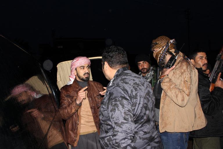 A tribal militia commander, Mohammed Khamis Abu Risha (L) talks with an Iraqi policeman in Malaab, a district of the Iraqi city of Ramadi on January 10, 2014