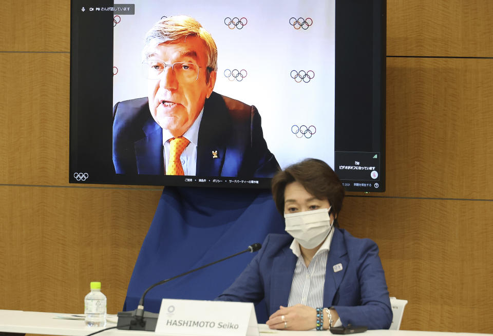 International Olympic Committee (IOC) President Thomas Bach delivers an opening speech on a screen at a meeting of the IOC Coordination Commission for the Tokyo 2020 Olympics in Tokyo on Wednesday, May 19, 2021, while Tokyo 2020 Olympics organizing committee President Seiko Hashimoto listens. Bach, Hashimoto, Japanese Olympic Minister Tamayo Marukawa and Tokyo Gov. Yuriko Koike attended a three-day meeting. (Yoshikazu Tsuno/Pool Photo via AP)