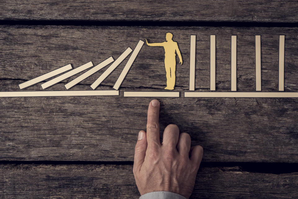 A hand points to a diagram that demonstrates stopping the domino effect with the outline of a person holding out a hand to stop a series of dominoes from continuing to fall