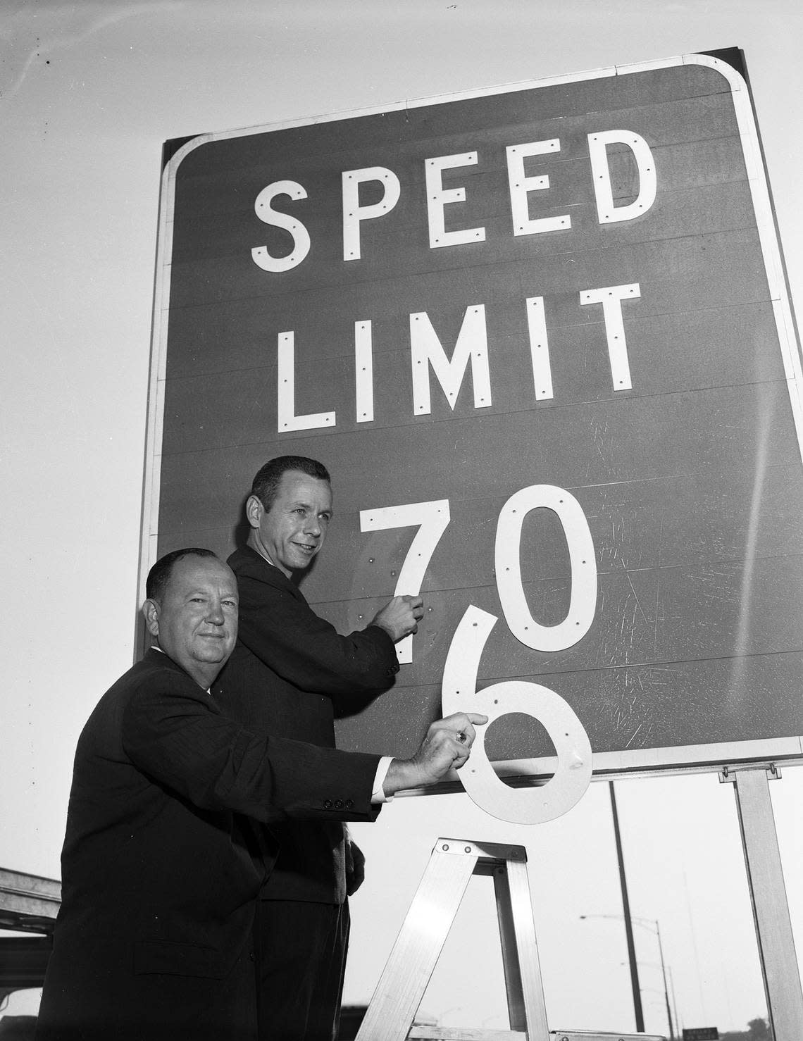 Aug. 28, 1961: Doyle Willis and Don Gladden pose as they appear to put up a 70 mph speed limit sign on the Dallas-Fort Worth Turnpike.
