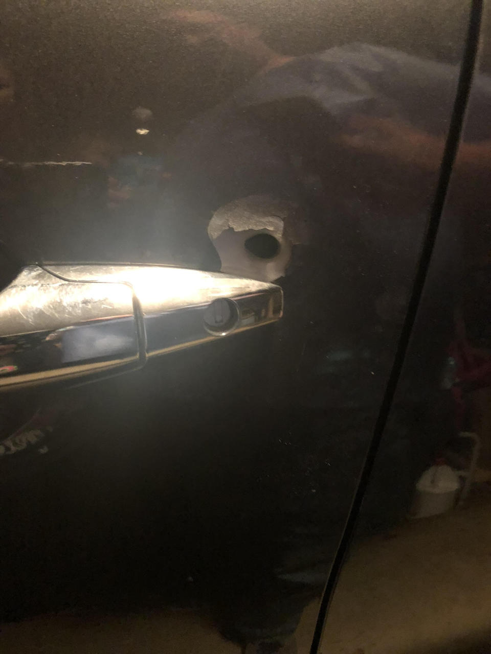 A bullet hole in the driver&rsquo;s side door of the car the author's husband was driving when he was attacked. (Photo: Courtesy of Colleen Dilthey Thomas)