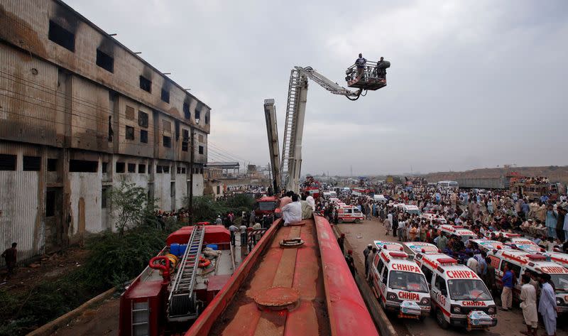 FILE PHOTO: Ambulances and fire brigade vehicles outside a building, after a fire at a garment factory in Karachi