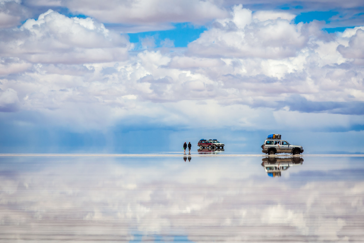 people crossing salar de uyuni in bolivia