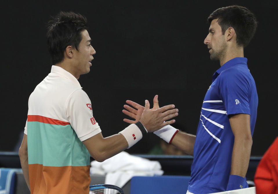 Japan's Kei Nishikori, left, congratulates Serbia's Novak Djokovic as he retired injured during their quarterfinal at the Australian Open tennis championships in Melbourne, Australia, Wednesday, Jan. 23, 2019. (AP Photo/Mark Schiefelbein)