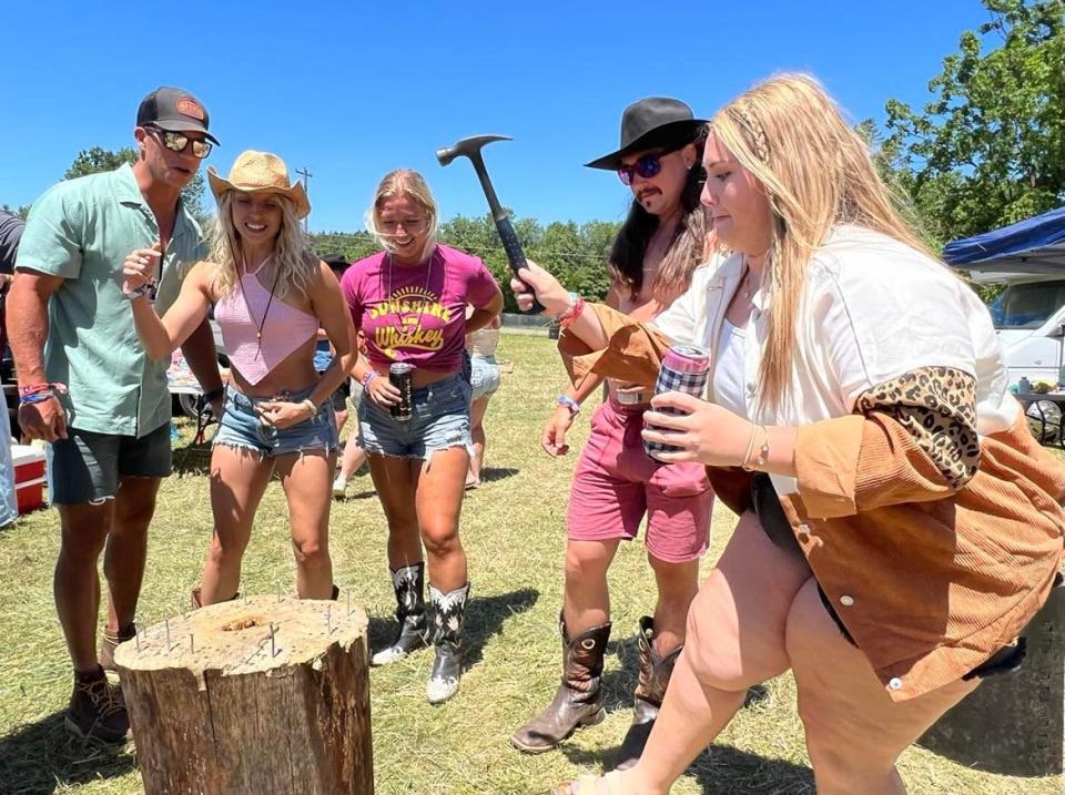 A group of Country Fest attendees play a drinking game on Saturday called, "Thump" in a tailgate lot at Clay's Resort Jellystone Park.