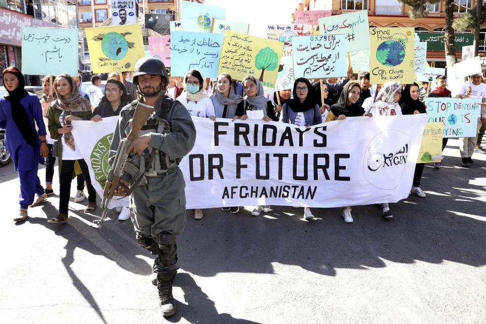 Young people attend a Climate Strike rally, as Afghan security forces guard them in Kabul, Afghanistan, Friday, Sept. 20, 2019. In the Afghan capital, where people are dying every day in horrific bomb attacks, a young generation, worried that if war doesn't kill them climate change will, took part in the global climate strike. (AP Photo/Ebrahim Noroozi)