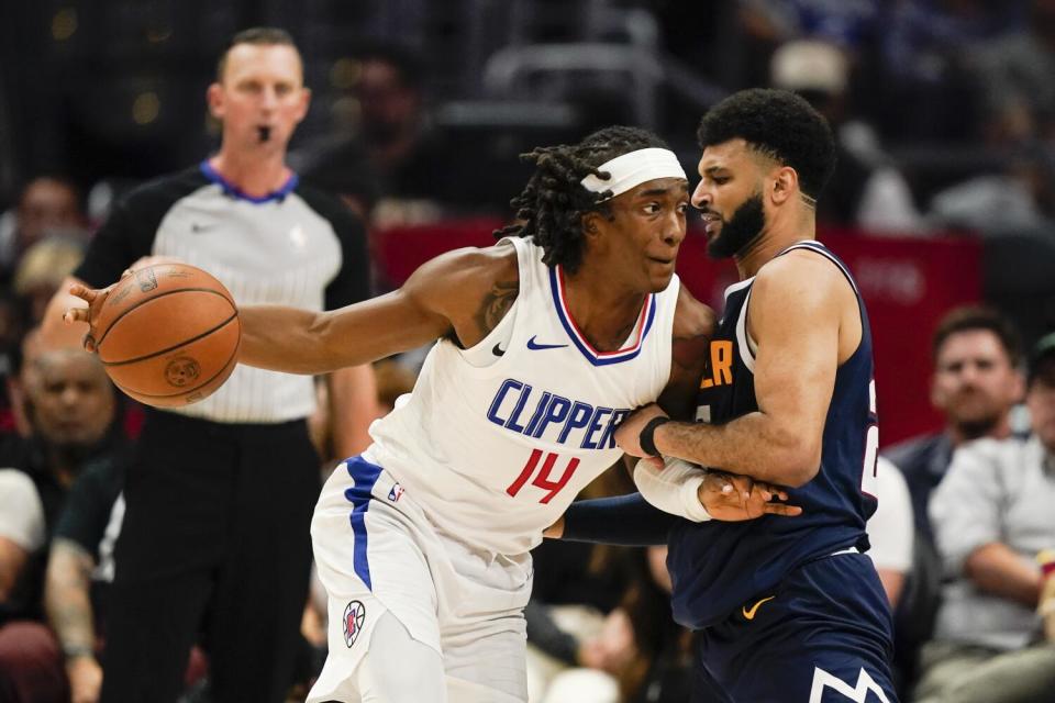 Terance Mann drives against Nuggets guard Jamal Murray in the Clippers' final preseason game Thursday.