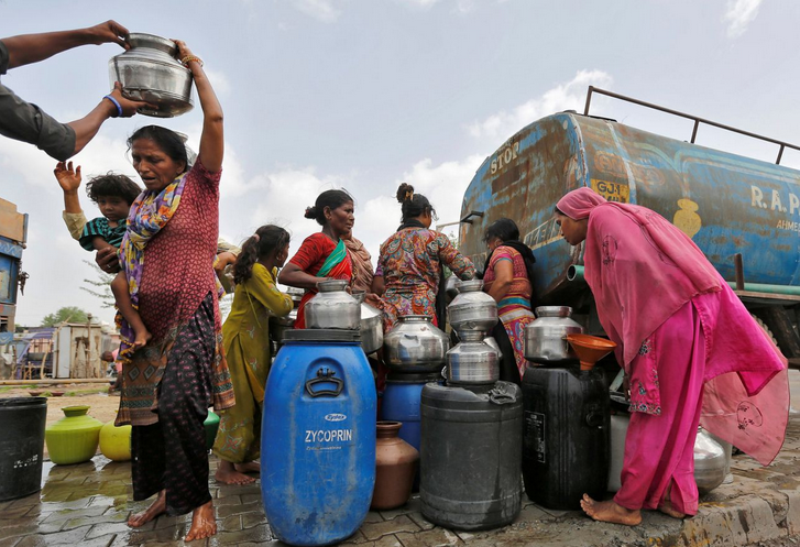 An einem außergewöhnlich heißen Tag im indischen Ahmedabad füllen Bewohner an einer Tankstation ihre Kanister mit Wasser. (Bild: Amit Dave/Reuters)