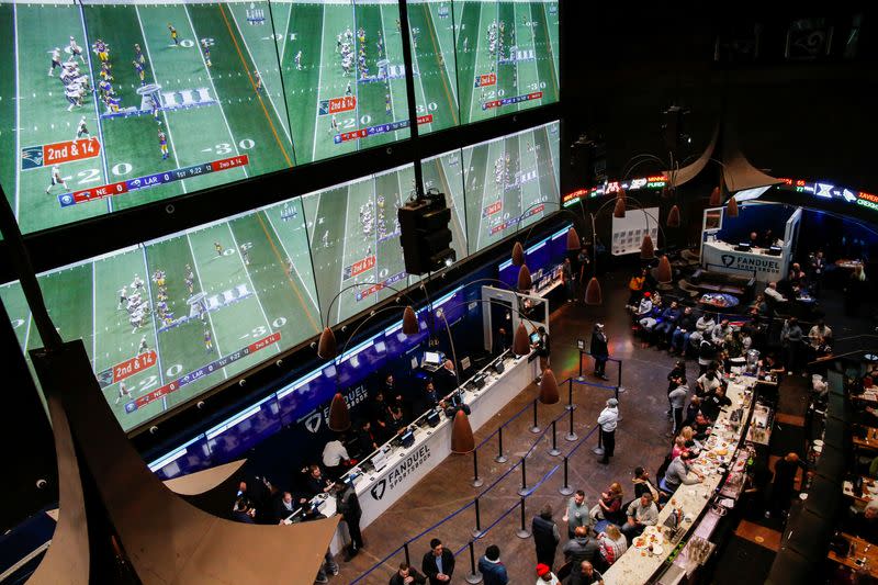 People make their bets at the FANDUEL sportsbook during the Super Bowl LIII in East Rutherford, New Jersey