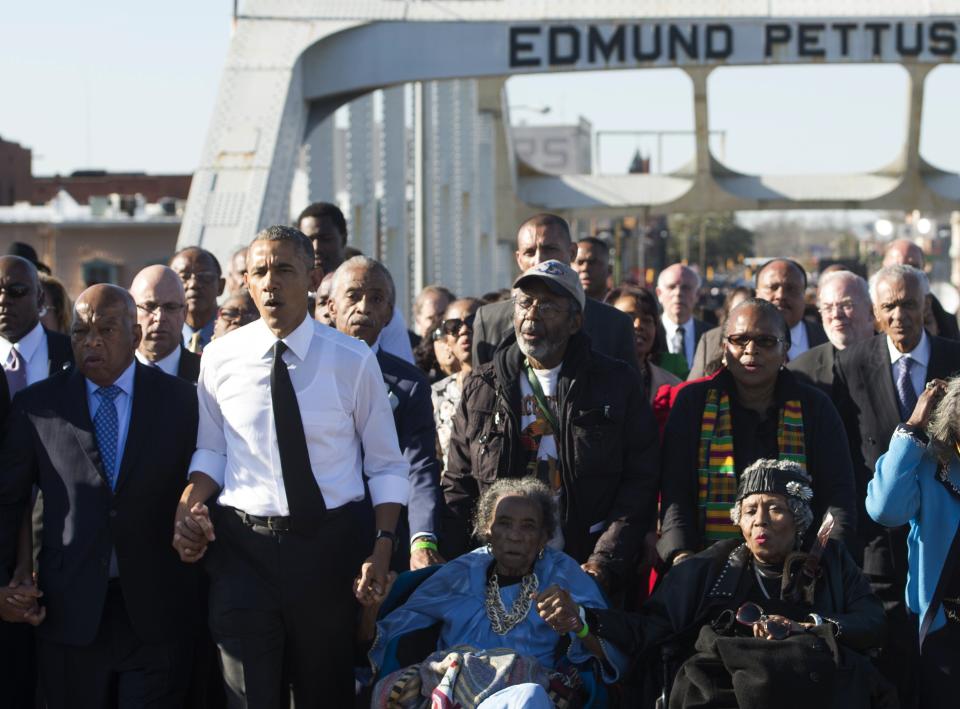 President Barack Obama (second from left) and U.S. Rep. John Lewis (left), a Democrat of Georgia and one of the original marchers, sing as they lead a walk across the Edmund Pettus Bridge to mark the 50th Anniversary of the Selma to Montgomery civil rights marches in Selma, Alabama, March 7, 2015. Obama rallied a new generation of Americans to the spirit of the civil rights struggle, warning their march for freedom "is not yet finished." In a forceful speech in Selma, Alabama, on the 50th anniversary of the brutal repression of a peaceful protest, America's first black president denounced new attempts to restrict voting rights.