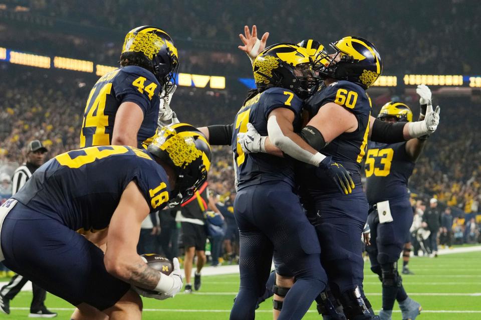 Michigan running back Donovan Edwards celebrates with Michigan offensive lineman Drake Nugent after a touchdown in the first quarter during the College Football Playoff national championship game against Washington at NRG Stadium in Houston on Monday, Jan. 8, 2024.