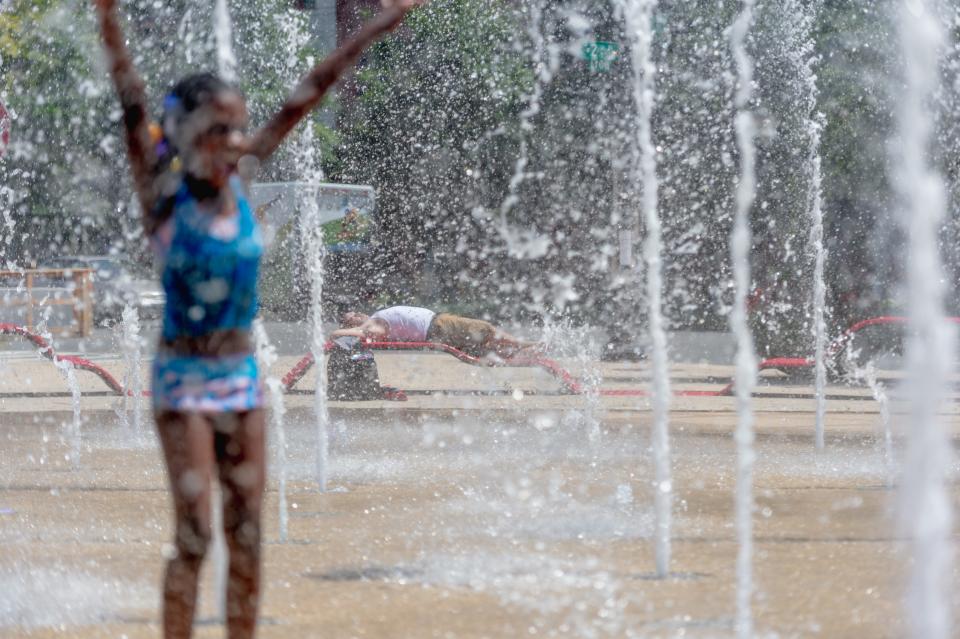 A man takes a nap July 17, 2019, near the fountain at Canal Park in Washington, D.C. The city's heat index values were predicted to reach 105 to 110 degrees. The nation's capital faces the hottest weather so far this summer as a heat wave is poised to spread across much of the central and eastern US over the next several days.