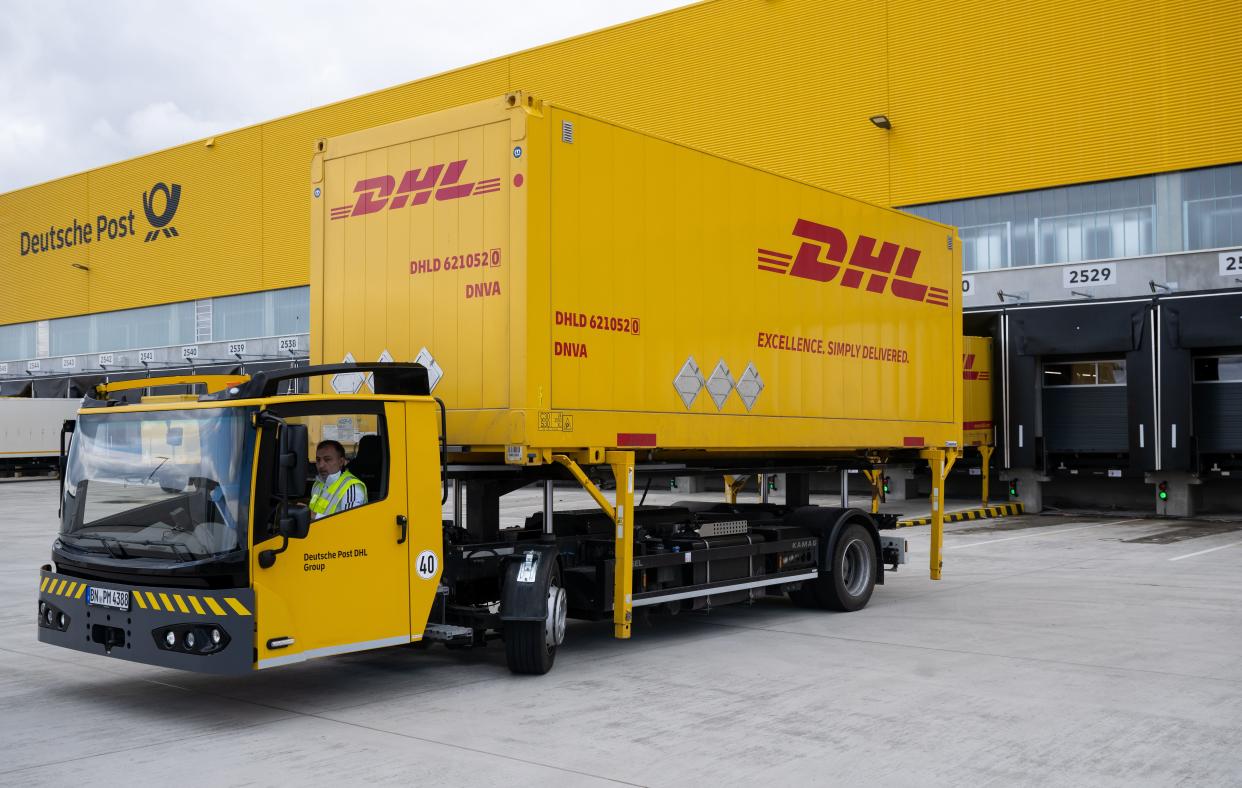Containers and vehicles with the DHL logo stand at the DHL parcel center. The connection to the existing parcel center creates the largest Deutsche Post DHL parcel processing site in Germany.
