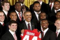 Ohio State Buckeyes team captain Michael Bennett (top row, 2nd R) holds his fingers behind U.S. President Barack Obama's head during a photo as Obama plays host to the reigning NCAA football champion Buckeyes in a reception at the East Room of the White House in Washington, April 20, 2015. REUTERS/Jonathan Ernst