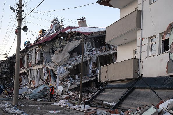 ELBISTAN, TURKEY - FEBRUARY 09: A rescue volunteer walks around collapsed buildings on February 9, 2023 in Elbistan Turkey. A 7.8-magnitude earthquake hit near Gaziantep, Turkey, in the early hours of Monday, followed by another 7.5-magnitude tremor just after midday. The quakes caused widespread destruction in southern Turkey and northern Syria and were felt in nearby countries.  (Photo by Mehmet Kacmaz/Getty Images)