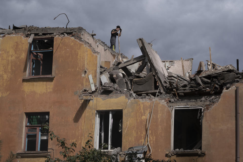 A firefighter works to extinguish a fire as he looks for potential victims after a Russian attack that heavily damaged a residential building in Sloviansk, Ukraine, Wednesday, Sept. 7, 2022. (AP Photo/Leo Correa)