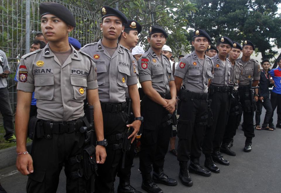 Indonesia police officers stand guard at Bali's international airport, Indonesia, Friday, April 25, 2014. A drunken passenger who caused a hijack scare on a Virgin Australia flight by trying to break into the cockpit was arrested Friday after the plane landed on Indonesia's resort island of Bali, officials said. (AP Photo/Firdia Lisnawati)