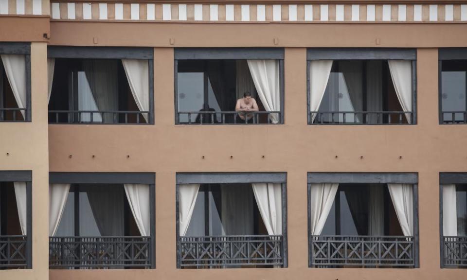 A man stands on a balcony of the H10 Costa Adeje Palace hotel in  Tenerife.