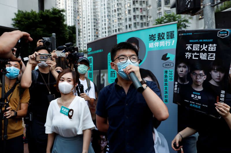 FILE PHOTO: Pro-democracy activists Tiffany Yuen Ka-wai and Joshua Wong attend a campaigning during primary elections aimed for selecting democracy candidates, in Hong Kong