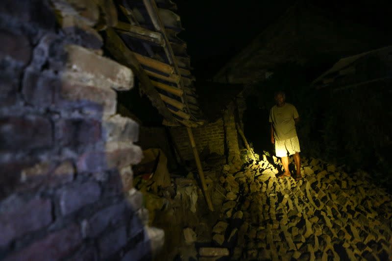 A resident stands near a damaged house after an earthquake struck off the Indonesian island of Java in Bantul