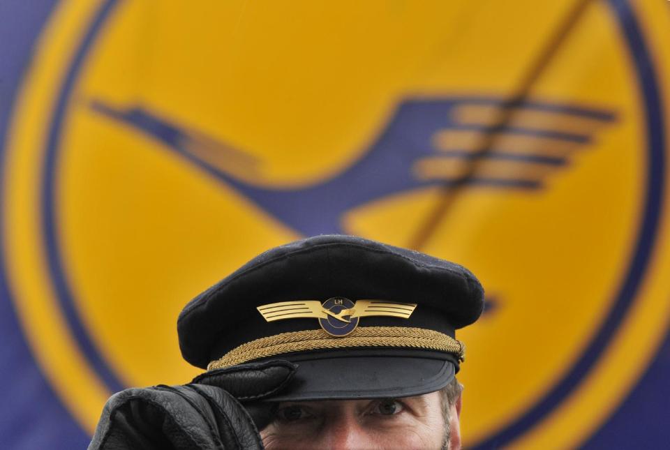 FILE - In this Feb. 22, 2010 file picture a pilot of German airlines Lufthansa waits in front of the company's logo at the airport in Frankfurt, Germany. Germany. Germany’s Lufthansa airline says it is canceling some 3,800 flights because of a three-day strike by the pilots’ union later this week, affecting 425,000 passengers. The airline, Germany’s biggest, said Monday March 31, 2014 the cancellations include domestic and intercontinental connections and are being done in preparation for what is expected to be “one of the biggest strikes in Lufthansa’s history.” Lufthansa says even though the strike starts Wednesday, some Tuesday connections have been canceled for logistic reasons. Lufthansa, Lufthansa Cargo and the company’s budget airline Germanwings are all affected. (AP Photo/dpa,Boris Roessler,File)