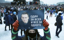 FILE - file photo, Jan. 23, 2021, a man holds a poster with a portrait Alexei Navalny and reads: 'One for all and all for one', during a protest rally against the jailing of opposition leader Alexei Navalny in St. Petersburg, Russia. Allies of Navalny are calling for new protests next weekend to demand his release, following a wave of demonstrations across the country that brought out tens of thousands in a defiant challenge to President Vladimir Putin. (AP Photo/Dmitri Lovetsky, File)
