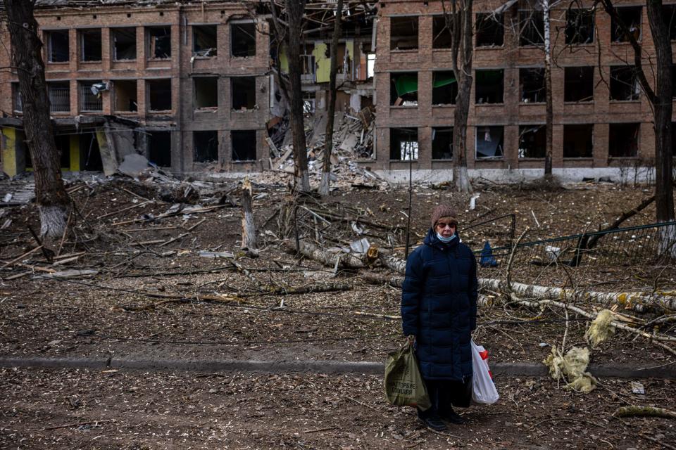 A woman stands in front of a destroyed building after a Russian missile attack in the town of Vasylkiv, near Kyiv, on February 27, 2022. Ukraine's foreign minister said on February 27, that Kyiv would not buckle at talks with Russia over its invasion, accusing President Vladimir Putin of seeking to increase "pressure" by ordering his nuclear forces on high alert.