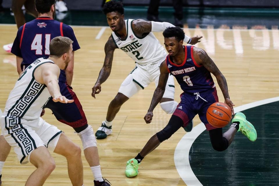 Detroit Mercy guard Antoine Davis dribbles against Michigan State guard Rocket Watts (2) and forward Thomas Kithier during the first half at the Breslin Center in East Lansing, Dec. 4, 2020.
