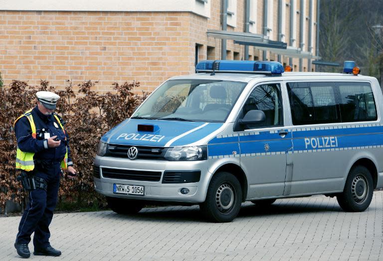 A policeman stands next to a police car in front of a house in Duesseldorf, western Germany, on March 26, 2015, during the investigation into the Germanwings plane crash over the French Alps