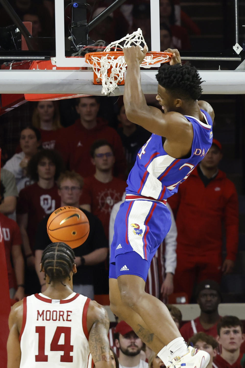 Kansas forward KJ Adams Jr., top, dunks against Oklahoma forward Jalon Moore (14) during the second half of an NCAA college basketball game Saturday, Feb. 17, 2024, in Norman, Okla. (AP Photo/Garett Fisbeck)