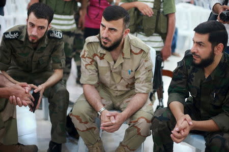 Zahran Alloush (C), commander of Jaysh al Islam, sits during a conference in the town of Douma, eastern Ghouta in Damascus, Syria August 27, 2014. REUTERS/Bassam Khabieh