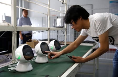 An engineer tests a "Xiaoyi" robot, a Siri-like voice assistant, at the headquarters of Lanchuang Network Technology Corp in Weifang