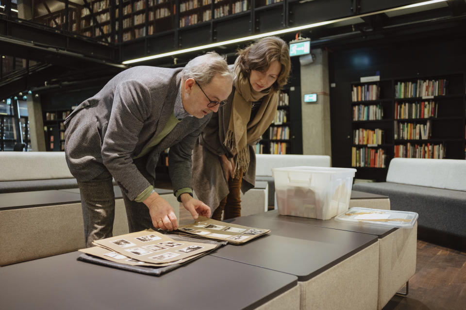 This handout picture shows Maciej Grzywaczewski, left, the son of Z. L. Grzywaczewski, with curator Zuzanna Schnepf-Kołacz, as they check the negatives and pictures taken by Polish firefighter Zbigniew Leszek Grzywaczewski showing the ghetto of Warsaw during the uprising of 1943, in Gdansk, Poland, Dec. 19, 2022. On Wednesday, Jan. 18, 2023, Warsaw’s Jewish history museum presented a group of photographs taken in secret during the Warsaw Ghetto Uprising of 1943, some of which have never been seen before, that were recently discovered in a family collection. (Maciek Jazwiecki/POLIN Museum via AP)