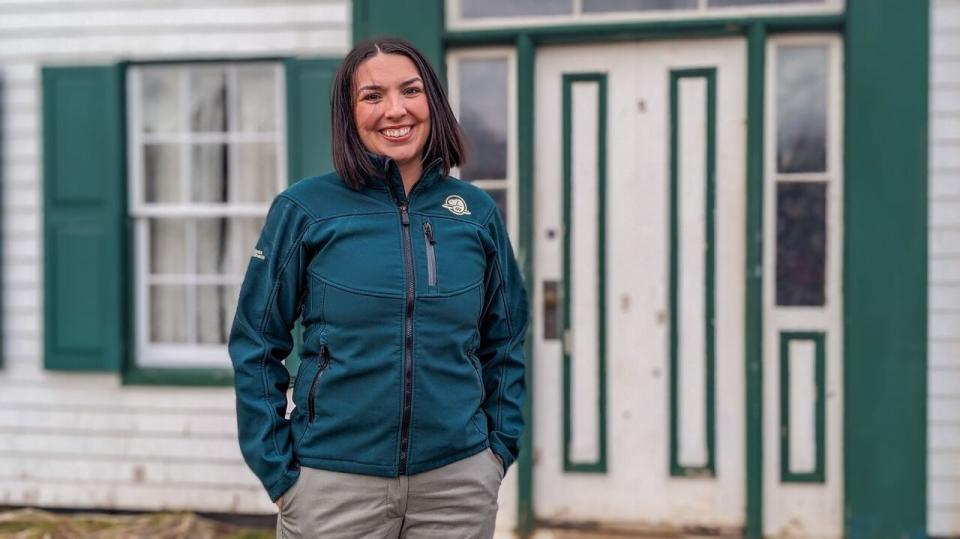 Kassandra McKinnon, acting National Historic Sites Manager with Parks Canada, stands in front of the iconic front door at Green Gables house.  