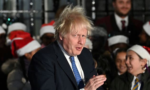 Prime Minister Boris Johnson applauds the choir as he attends the switch on of the Christmas tree lights outside 10 Downing Street last night. (Photo: JUSTIN TALLIS via Getty Images)